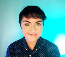 Imagen del busto de Vic Syerix. Tiene el pelo muy corto y rojo. Ojos azules y labios pintados de azul.